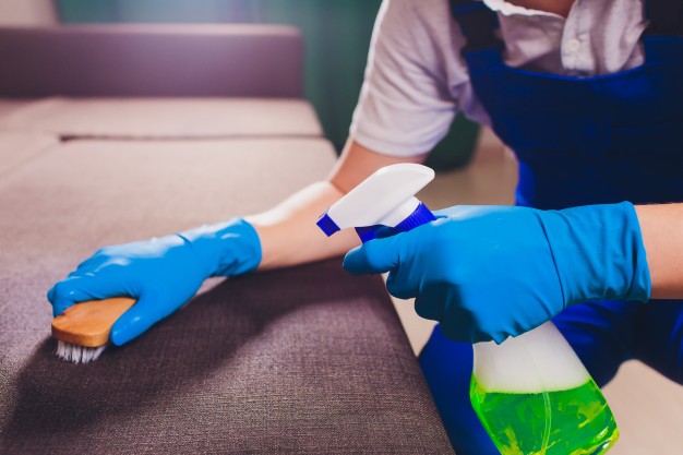 male-hand-light-blue-protective-gloves-cleaning-sofa-couch-room_152904-1706