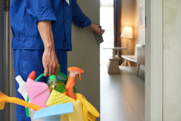 unrecognizable-cleaner-walking-into-hotel-room-with-tools-detergents_1098-17830